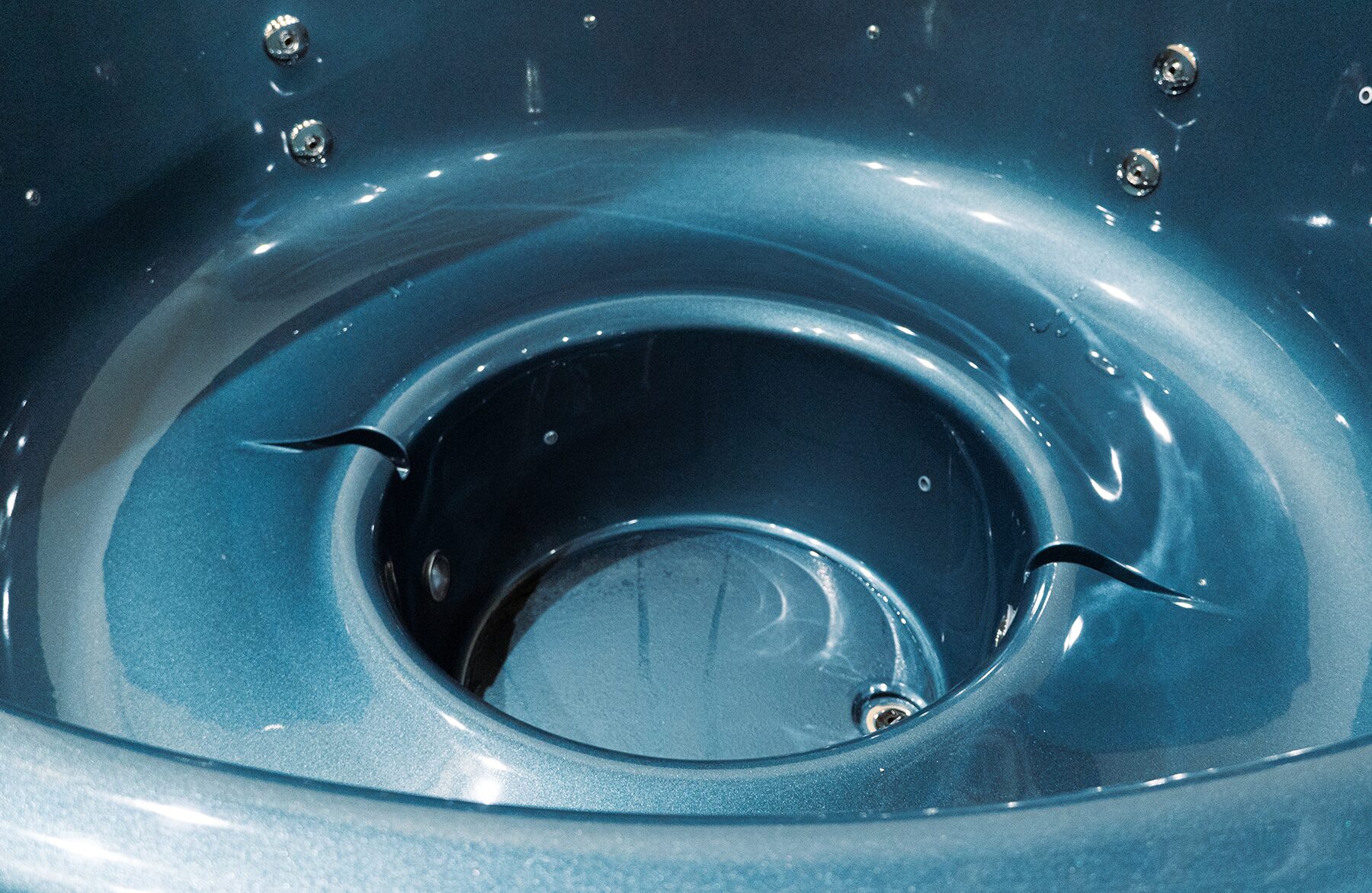 Detailansicht der blauen Innenwanne des Feuerbad Hot Tubs LUNA mit ergonomischer Sitzform, integrierten Düsen und Wasserablauf