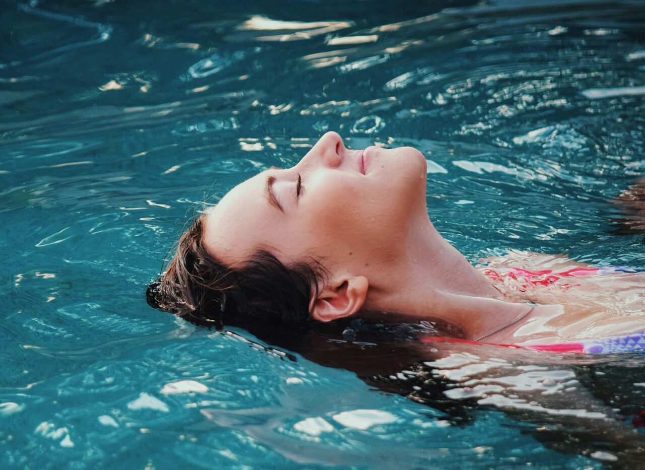 Person treibt entspannt auf dem Rücken im warmen Wasser eines Hot Tub Pools