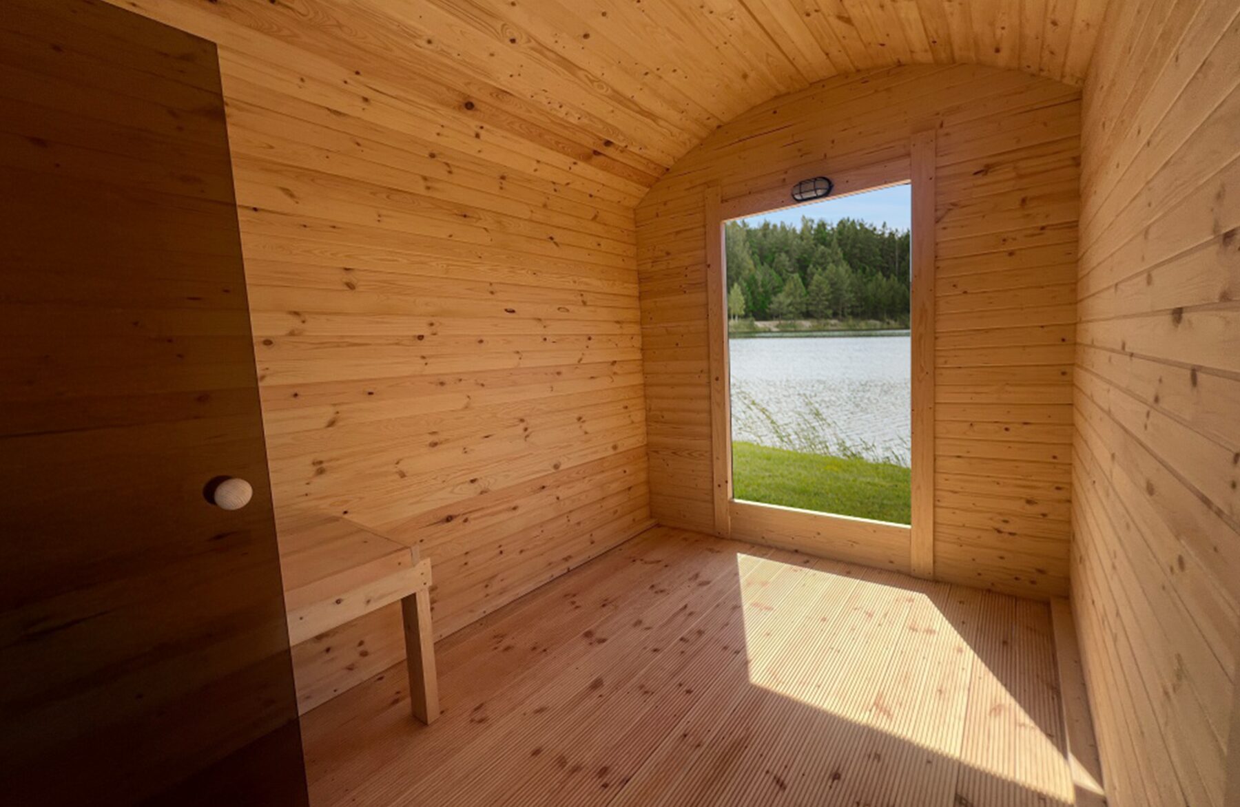 Innenansicht der Feuerbad Sauna CERES mit heller Holzverkleidung, integrierter Sitzbank und Glastür