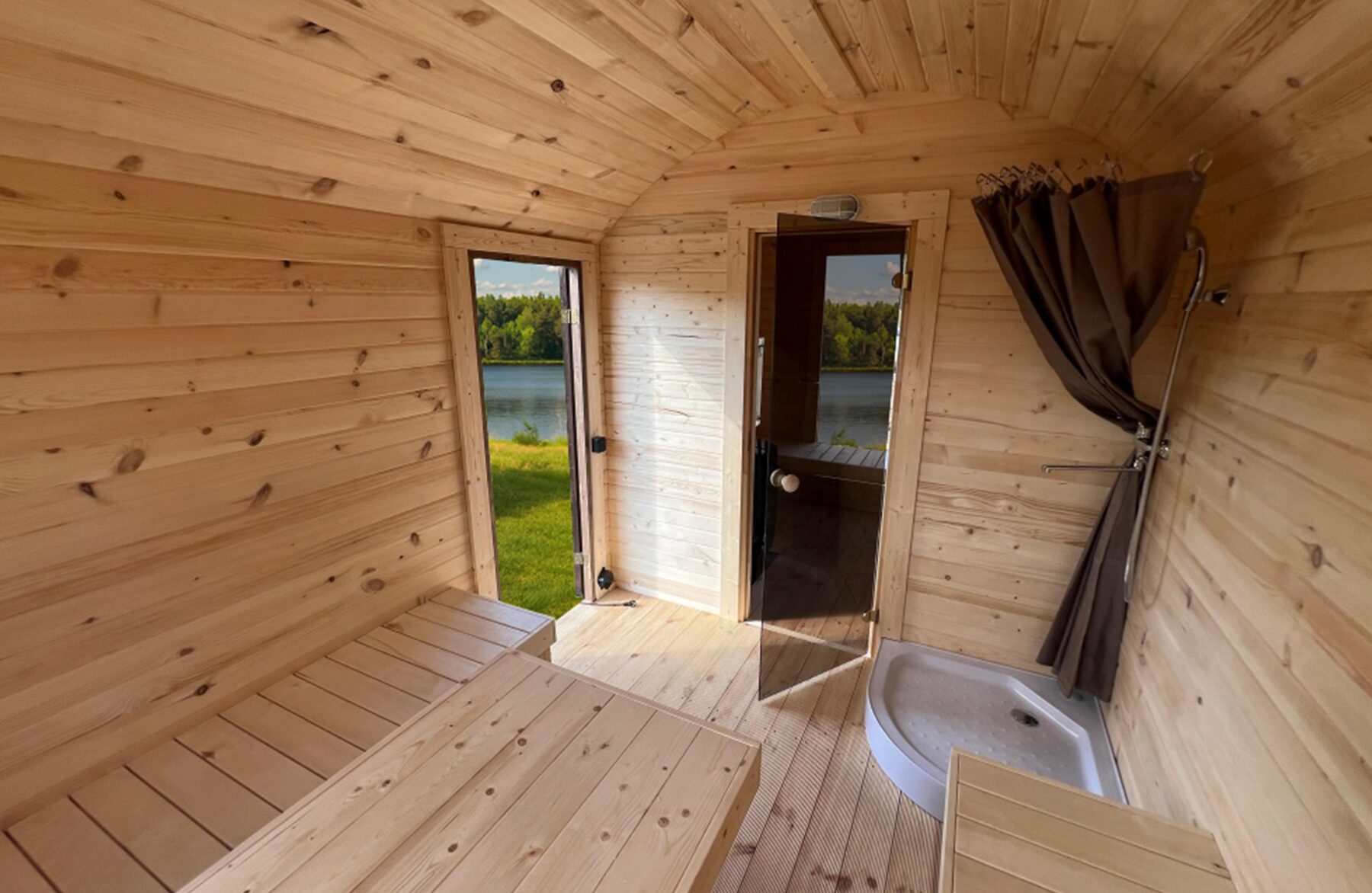 Innenansicht der Feuerbad Sauna CERES mit heller Holzverkleidung, integrierter Sitzbank, Dusche und Glastür
