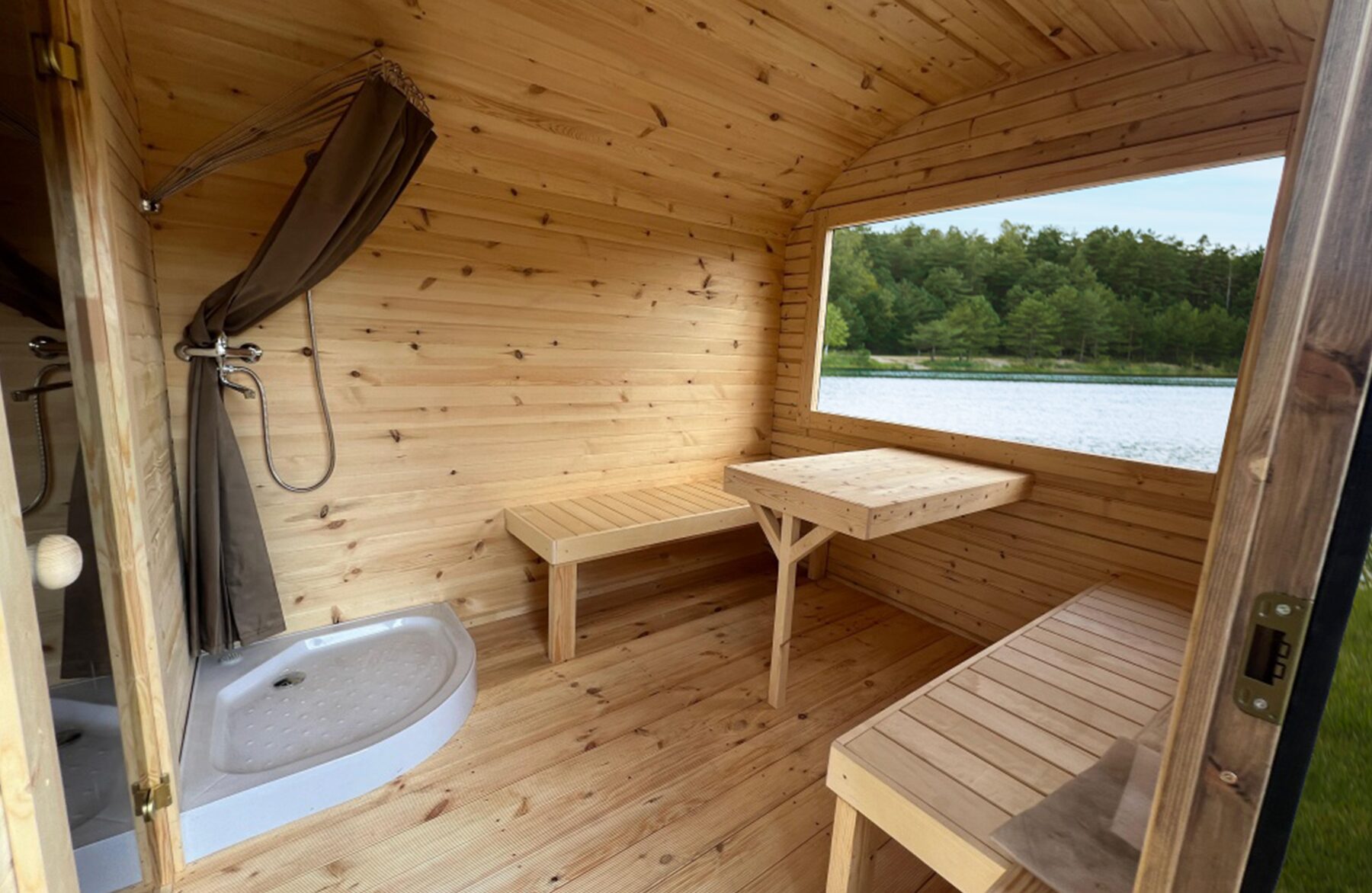 Innenansicht der Feuerbad Sauna CERES mit heller Holzverkleidung, integrierter Sitzbank, Dusche und Glastür